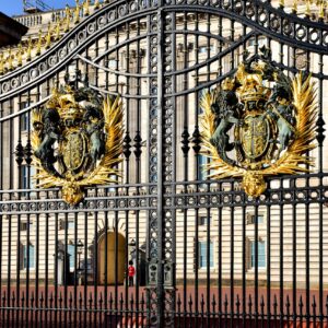 Elegant golden gates of Buckingham Palace in London, featuring intricate royal crests and detailed design.